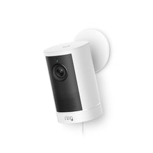 Ring Outdoor Camera 4K Plus Plug-in blanca en soporte circular de pared sobre fondo blanco, inclinada hacia abajo